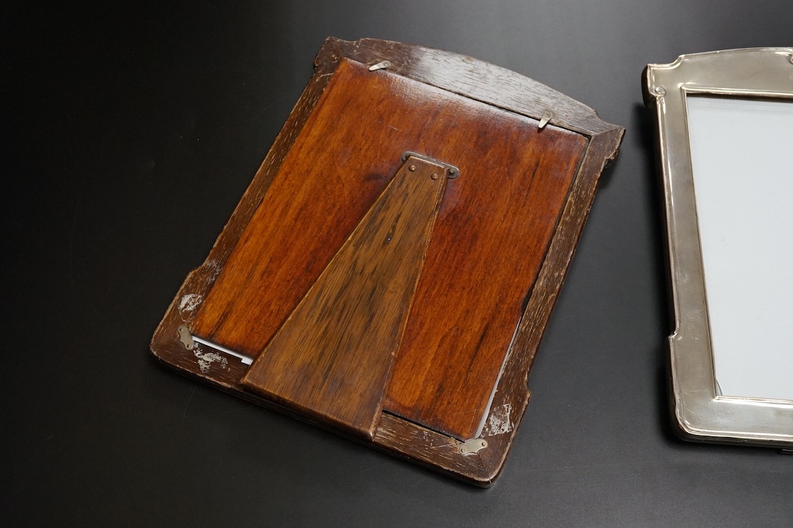 A pair of George V silver mounted shaped rectangular photograph frames, William Neale & Son Ltd, Birmingham, 1922 & 1925, 26.7cm.